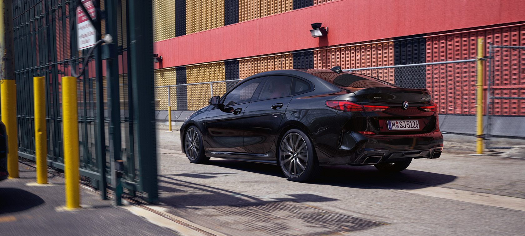 BMW M235i xDrive Gran Coupé F44 Black Sapphire metallic three-quarter rear view driving