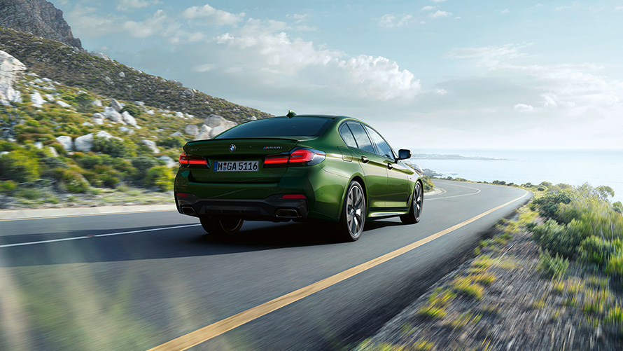 BMW M550i xDrive Sedan G30 LCI Facelift 2020 BMW Individual Verde Ermes metallic three-quarter rear view driving